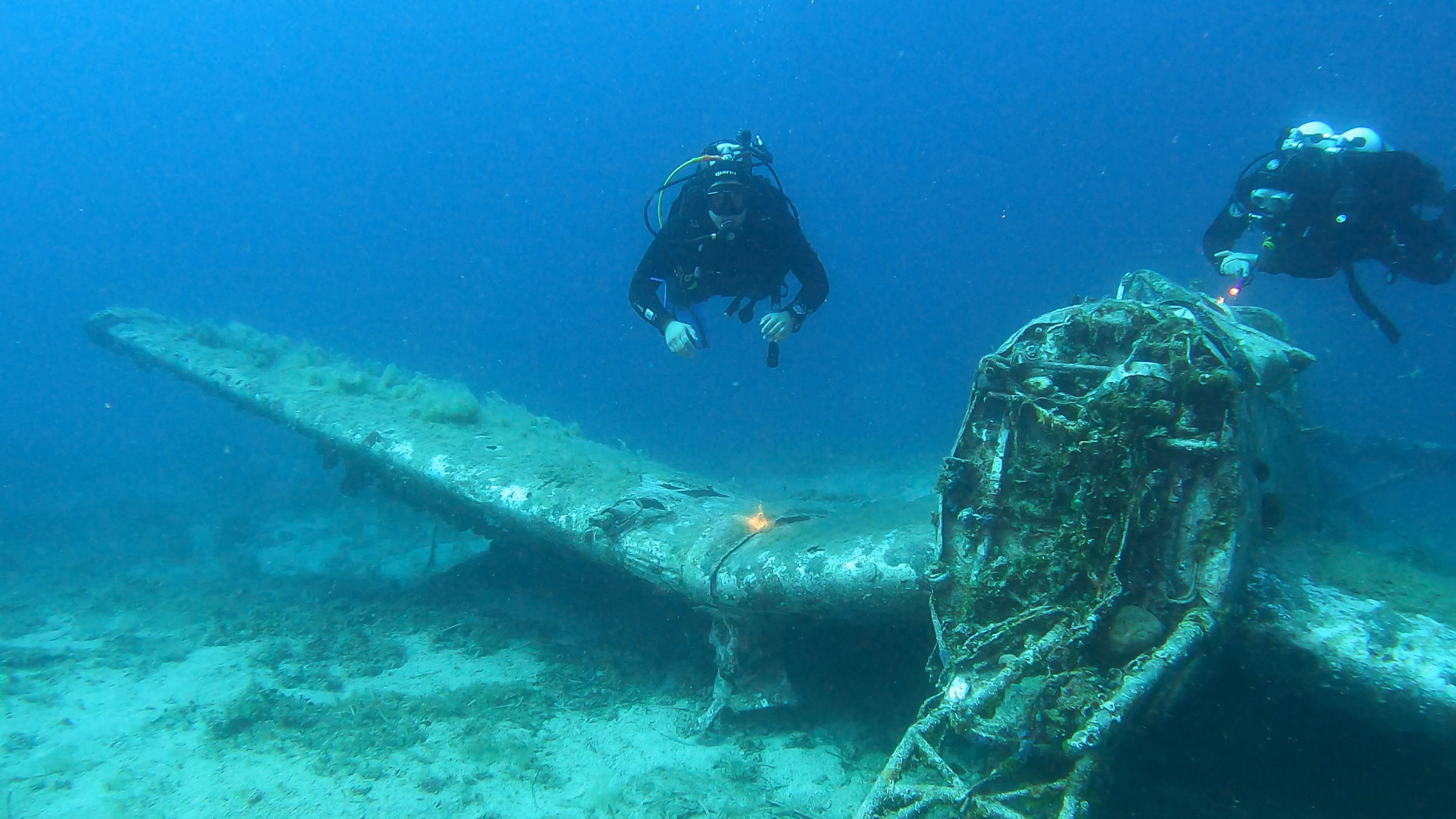 Underwater wreck of the Junkers Ju 87 or Stuka (from Sturzkampfflugzeug, „dive bomber“) seen from the front with two diver around it