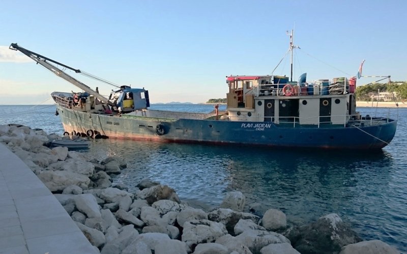 Boat Plavi Jadran seen delivering cargo near the shore